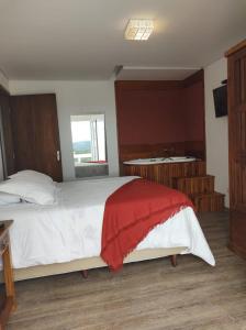 坎波斯杜若尔当Pousada Miraggio的一间卧室配有一张带红色毯子的床