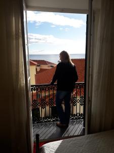 丰沙尔彭邵米拉索尔酒店的站在阳台上望出门的女人