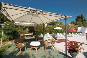 萨武德里亚Villa Anna的庭院配有桌椅和遮阳伞。