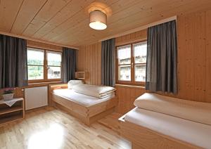 施科佩尔瑙坎德包尔霍夫农家乐的配有木墙和窗户的客房内的两张床
