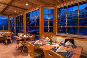 采尔马特西尔瓦娜山酒店的餐厅设有桌椅和大窗户。