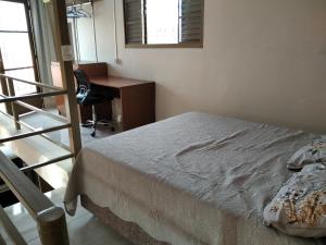 博图卡图Loft em Botucatu prox unesp rubiao jr的一间卧室配有一张床、一张桌子和一把椅子