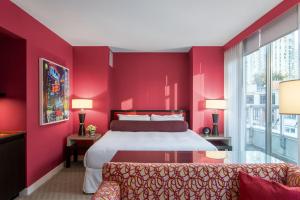 温哥华OPUS Vancouver的红色卧室配有床和沙发