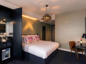 阿姆斯特丹阿姆斯特丹斯劳特戴克站美居酒店的酒店客房,配有床、桌子和椅子