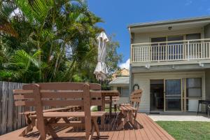波因特卢考特潘达努斯棕榈度假酒店的庭院设有木凳和遮阳伞。