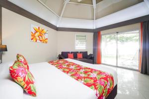 延根科洛村酒店的一间卧室设有一张大床和一个大窗户