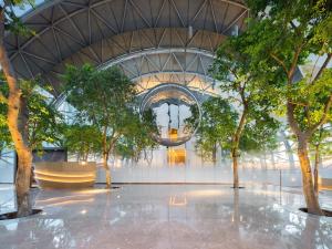 重庆重庆来福士洲际酒店的一座带天花板的建筑里,有树木的大堂