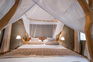 雅拉Leopard Safaris Yala的一间卧室配有一张带天蓬的床
