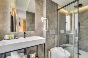 巴黎美妙停留酒店的一间带水槽、卫生间和淋浴的浴室