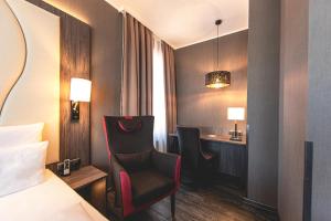 诺德施泰特PLAZA Premium Parkhotel Norderstedt的酒店客房,配有一张床、一张桌子和椅子