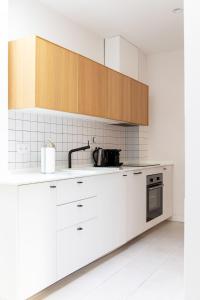 塞维利亚Tinto Townhouse by Olala Homes的厨房配有白色家电和木制橱柜