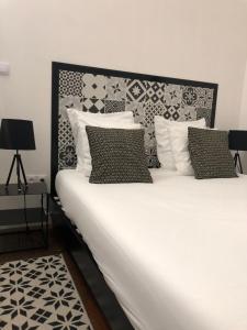 亚眠Ginkgo Maison d'hôtes的白色的床,配有黑白枕头
