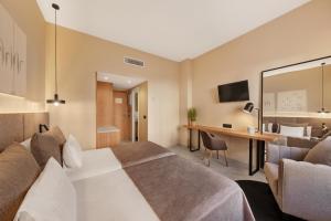 马略卡岛帕尔马阿尔姆戴纳酒店的配有一张床和一张书桌的酒店客房