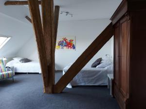 Piaam皮母斯戴特住宿加早餐旅馆的阁楼卧室设有两张床和木横梁。