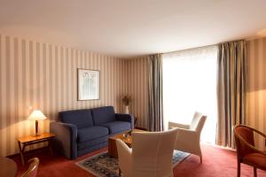 斯特拉斯堡让塞巴斯蒂安巴驰酒店的客厅配有蓝色的沙发和桌子