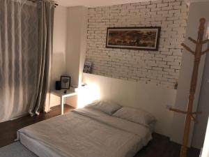 Tanzi光鹿旅人短期月租出租的一间卧室设有一张床和砖墙