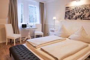 布拉希里恩Hotel Hof Holm的一间卧室配有一张大床、一张桌子和一个窗户。