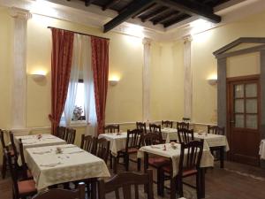 萨沃纳Casale Certosa的一间带桌椅的用餐室和窗户。