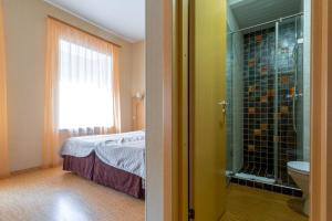 圣彼得堡赫尔岑旅馆的浴室设有床铺和玻璃淋浴间。