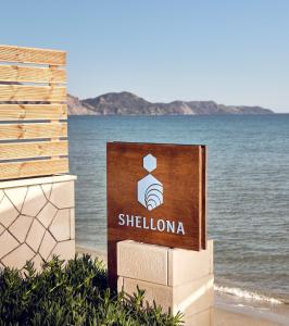 扎金索斯镇Shellona Rooms & Apartments的海滩上的标志,以海洋为背景