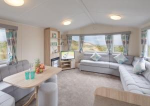 OrbyStunning 6 Birth Caravan in Skegness Herons Mead的客厅配有沙发和桌子