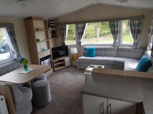 OrbyStunning 6 Birth Caravan in Skegness Herons Mead的一个带沙发和桌子的大篷车客厅