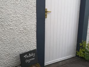 BuchlyviePrivate Cottage Bothy near Loch Lomond & Stirling的白色门旁的黑板标志