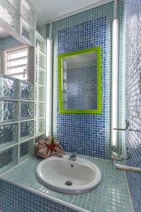 圣罗斯Villa de 2 chambres a Sainte Rose a 500 m de la plage avec vue sur la mer piscine privee et jardin clos的蓝色瓷砖浴室设有水槽和镜子