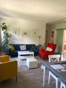 因斯布鲁克Apartment Ida的客厅配有蓝色的沙发和红色的椅子