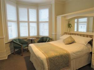 伦敦马普尔住宿加早餐旅馆的一间卧室配有一张床、两把椅子和窗户