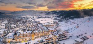 Białka Tatrzanska巴尼亚温泉与滑雪酒店的日落时分在雪中欣赏城镇的空中景色