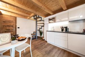 奥斯塔Aosta Centre Apartments - Martinet 17的厨房配有白色橱柜和桌椅
