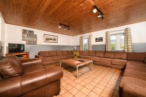WeathercoteOld School House -Yorkshire Dales National Park的客厅配有棕色皮沙发和桌子