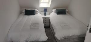 Portknockie4-Bed Cottage in Portknockie Near Cullen Moray的两张睡床彼此相邻,位于一个房间里