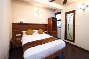 古莉Tropic Tree Maldives的一间卧室配有一张大床和镜子
