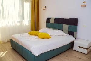 杜博瓦乡BLISS Dubova的一间卧室配有一张带黄色枕头的床。