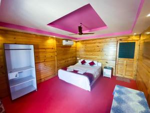 阿贡达Om Sai Beach Huts的一间卧室设有一张床和紫色天花板