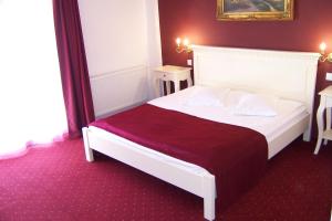 雅西天鹅绒旅馆的卧室配有一张带红色毯子的白色床