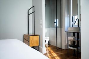 埃斯托利尔A House in Estoril - Adults Only的一间带一张床的卧室和一间带镜子的浴室