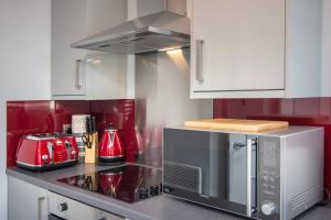 布莱克浦New Luxury Seaview Apt2 Free Parking Special Deal的厨房配有炉灶和微波炉。