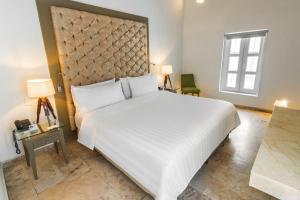 卡塔赫纳GHL Collection Armería Real Hotel的卧室设有一张白色大床和一扇窗户。