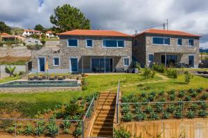 滨海雅尔丁Villa Flora - Nature & Tranquility - Heated pool optional的一座带蓝色窗户和庭院的石头房子