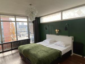 阿尔梅勒安诺酒店的一间卧室设有一张大床和绿色的墙壁