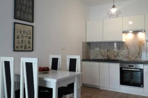 华沙Lux Apartment close to Medicover and Paley的厨房配有白色橱柜和水果桌