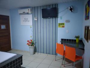 MaritubaPousada Tropical (Adults Only)的厨房配有橙色椅子和一张桌子及一台电视