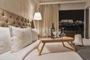 雅典A.P. Acropolis View Apartments的一间卧室配有一张带酒杯桌子的床