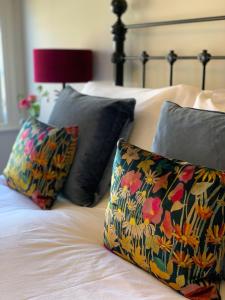 奇切斯特The Clock House的床上配有两个枕头和花卉枕头