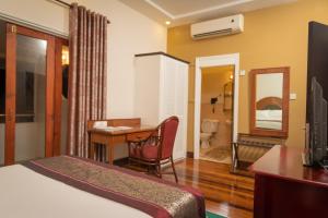 乔治敦赫德曼斯顿住宿酒店的酒店客房带一张床铺、一张书桌和一间卧室