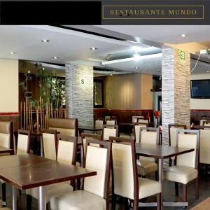 利马Hotel Mundo的配有木桌和白色椅子的餐厅
