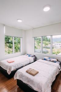 昆达桑格里斯美景小木屋的白色客房的两张床,设有窗户